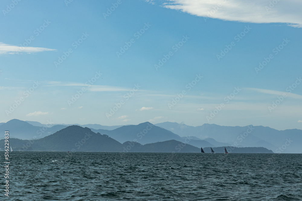 Boats, speedboats and sailboats in beautiful tropical landscape with blue sky and sunny day on the Brazilian coast in Ubatuba on Anchieta Island