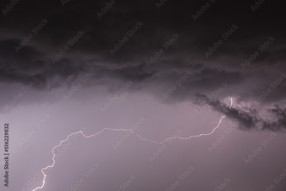 lightning with unusual shape from black storm cloud