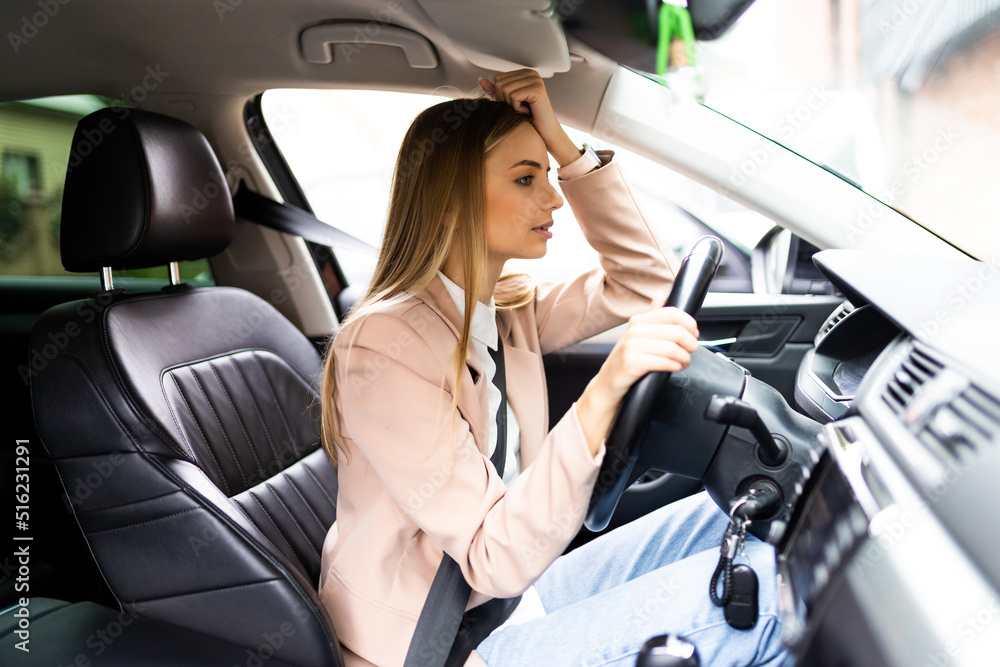 Stressed woman driver sitting inside her car on the road