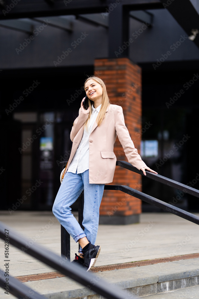 Young pretty woman talking on mobile phone on the street