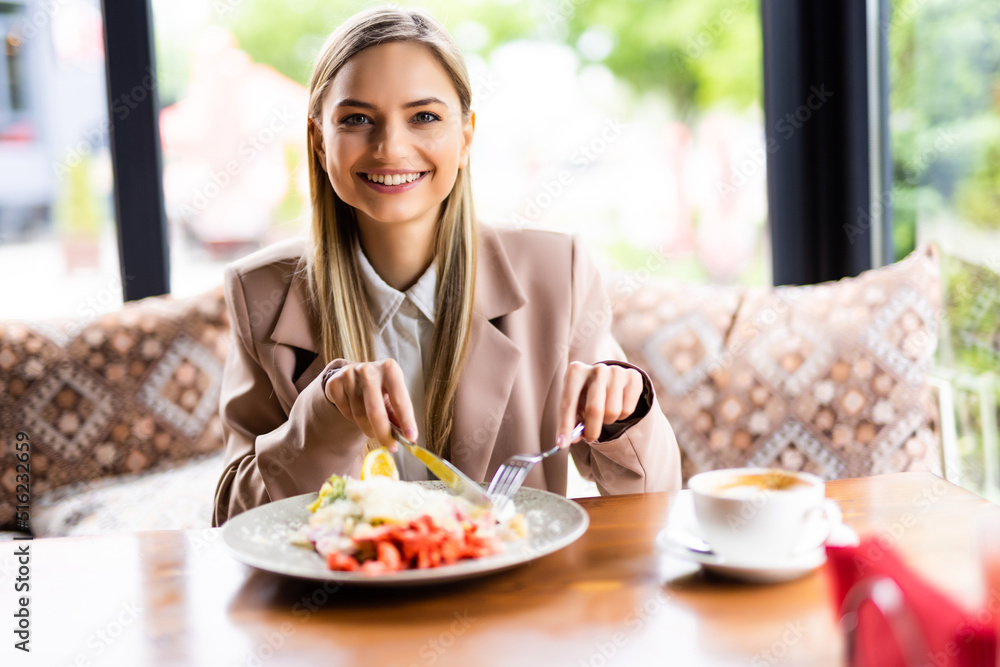 Young woman eating healthy salad on a restaurant terrace, feeling happy on a summer day Young woman eating healthy salad on a restaurant terrace, feeling happy on a summer day