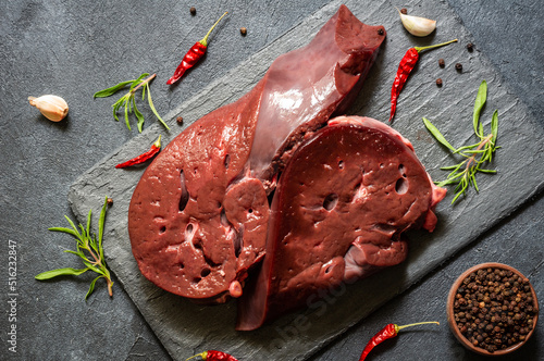 Принти на полотні Raw Beef liver meat on stone board with thyme and black peppers, cattle giblets