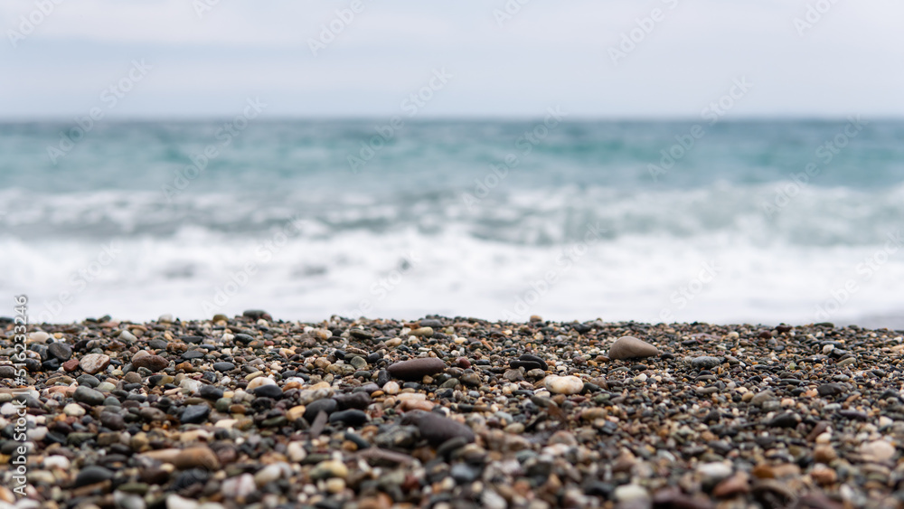 Sea stones and wave behind, pebble beach, Stones on blurred background of sea waves. Sea stones and wave behind, pebble beach, Stones on blurred background of sea waves.