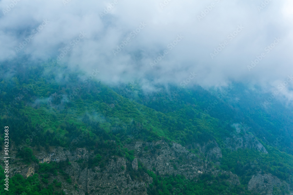 gloomy mountain landscape, wooded slopes covered with rain clouds