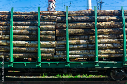 loaded railway wagons for carrying of logs close-up photo