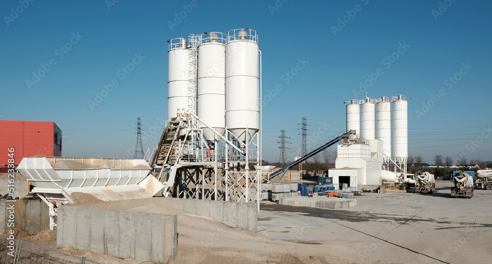 Obraz premium Scenery of concrete factory with white silos for production of concrete