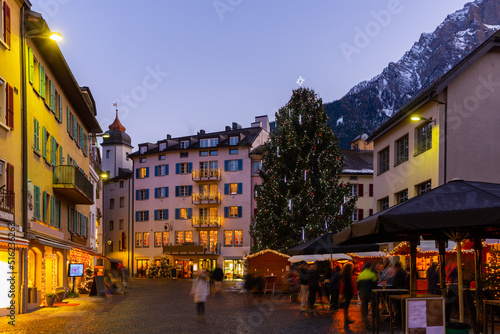 Evening view of central street in small mountainous Swiss town of Brig-Glis with main Christmas tree decorated 