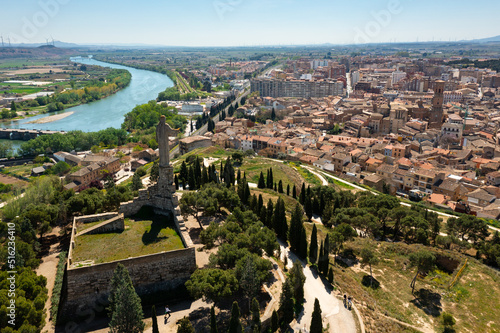 Scenic aerial view of Tudela cityscape on Ebro river from Cerro del Castillo with Monument to Sacred Heart of Jesus erected on hilltop on main tower of ruined castle on spring day, Navarre, Spain