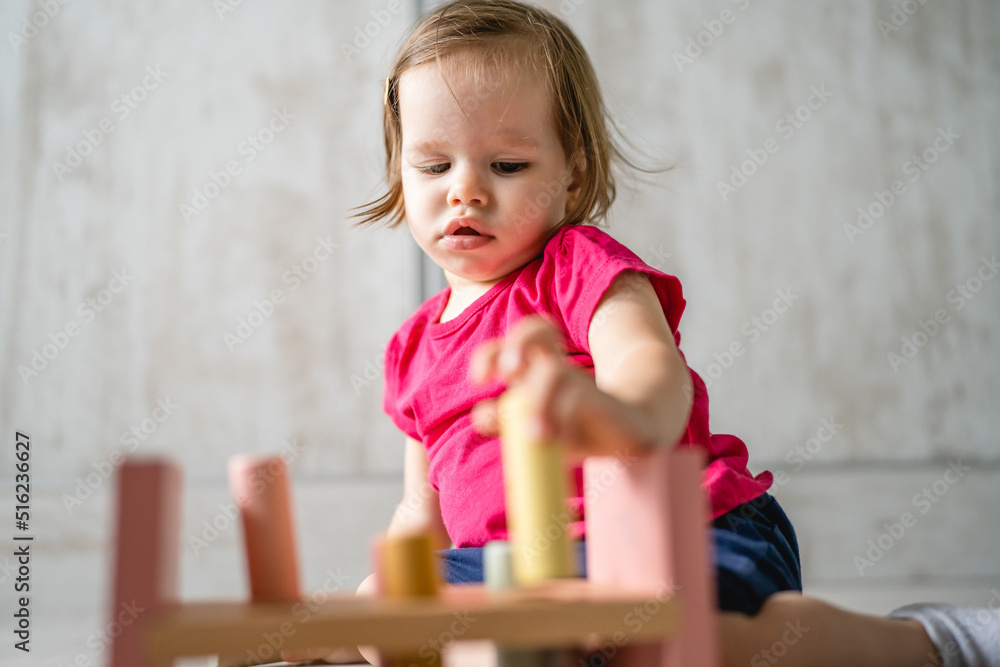 one child small caucasian girl little toddler playing with educational toys at home childhood and growing up early development concept copy space front view one child small caucasian girl little toddler playing with educational toys at home childhood and growing up early development concept copy space front view