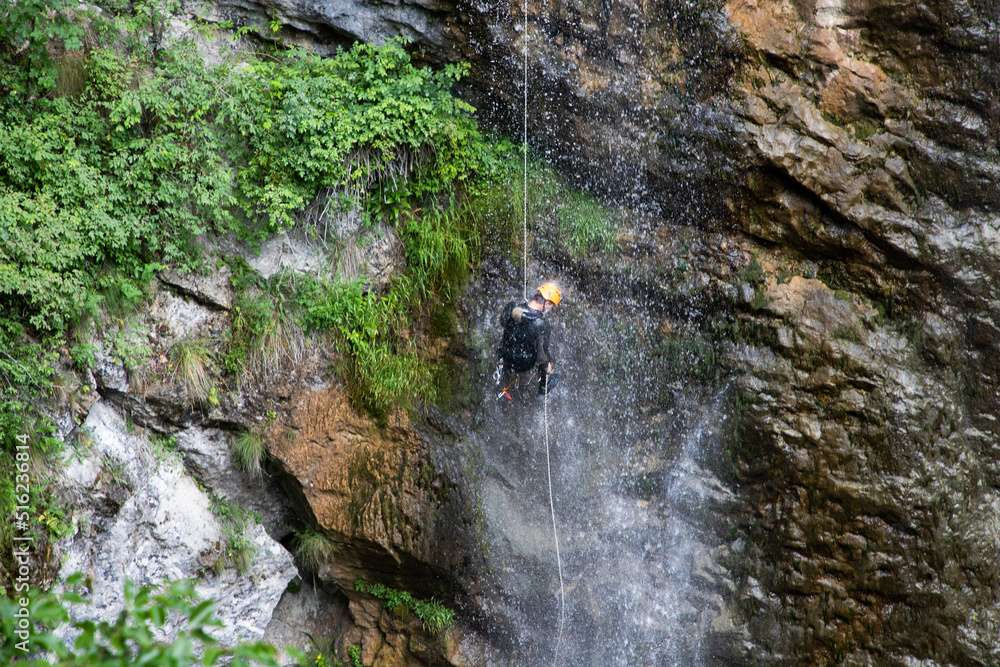 Obraz premium alpinist climbing down a waterfall