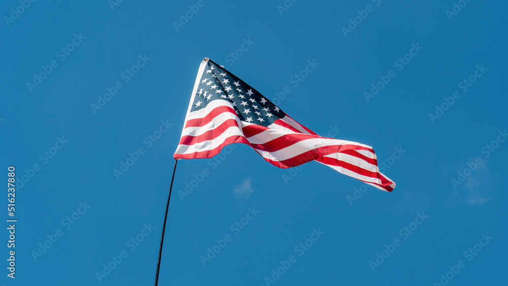 Fototapeta premium American flag waving against blue sky