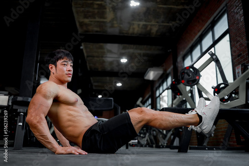 Photo of muscular man in gym on blurred background. Fitness and healthy lifestyle concept. Copy space.