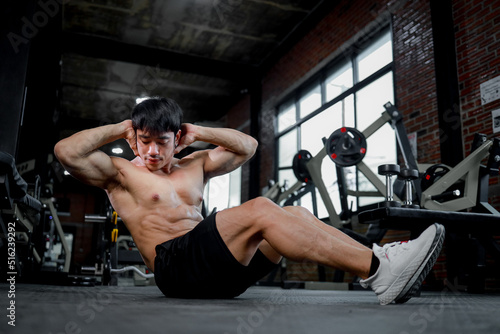 Photo of muscular man in gym on blurred background. Fitness and healthy lifestyle concept. Copy space.