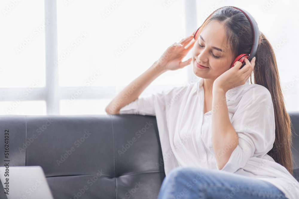 Young beautiful Asian woman girl in casual wear relaxing and listening to music headphones and working indoor Young beautiful Asian woman girl in casual wear relaxing and listening to music headphones and working indoor