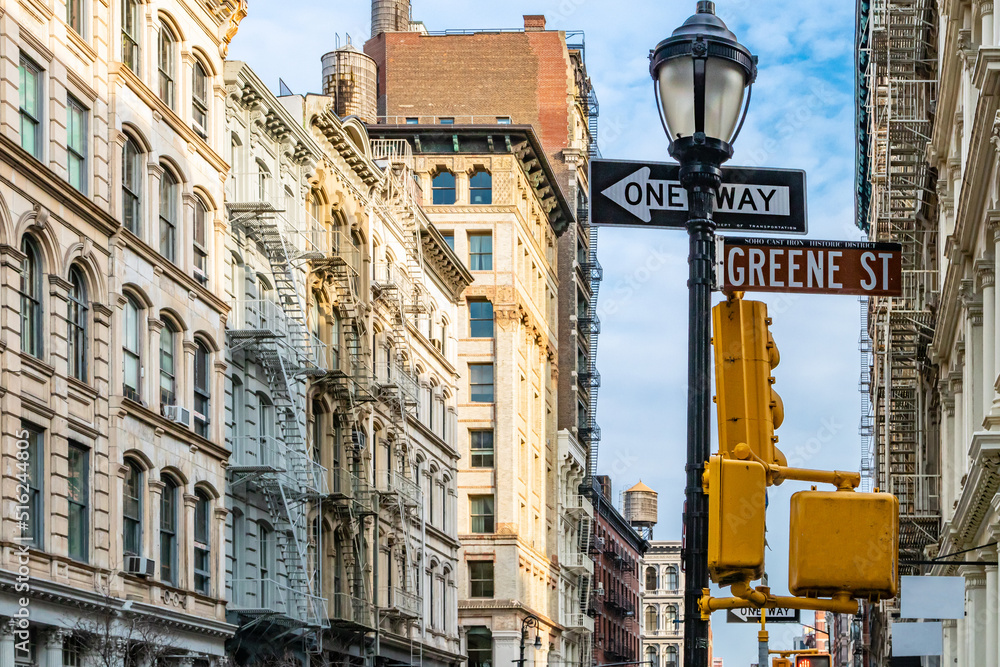 Greene Street sign and old historic buildings at an intersection in SoHo New York City