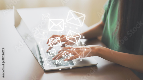 Email marketing and newsletter concept. Hand of woman using computer laptop and sending online message with email icon photo