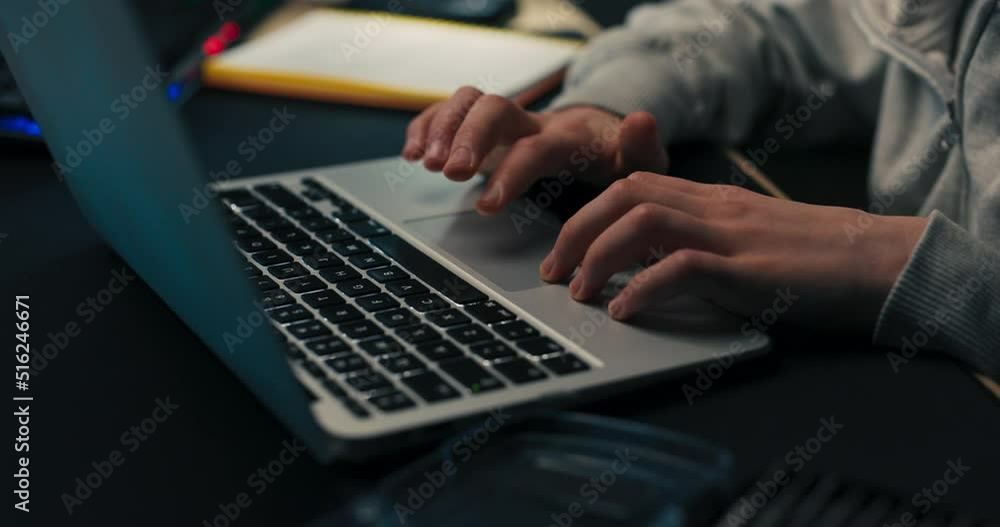 Young boy does homework, scrolls on laptop, works on computer, prepares document school project, child takes notes Young boy does homework, scrolls on laptop, works on computer, prepares document school project, child takes notes