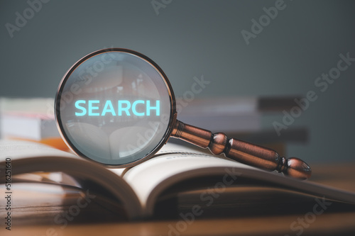 close up magnifier glass with search on a book, concept of finding or searching for idea, search for information, find out, Find the answer.