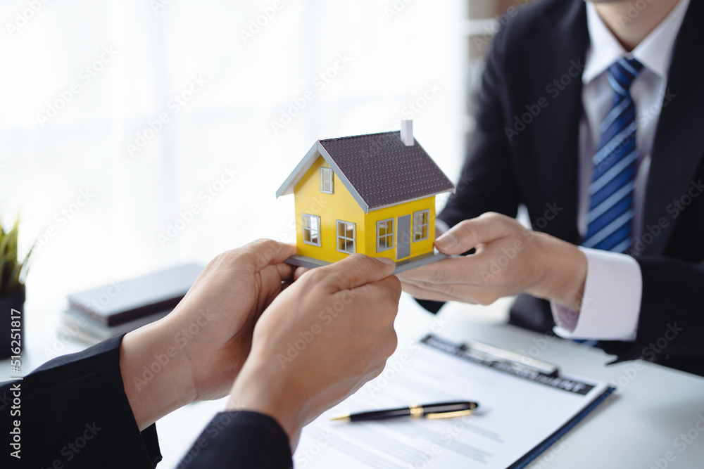 The real estate agent is explaining the home design to interested clients and signing an office sales contract. The real estate agent is explaining the home design to interested clients and signing an office sales contract.