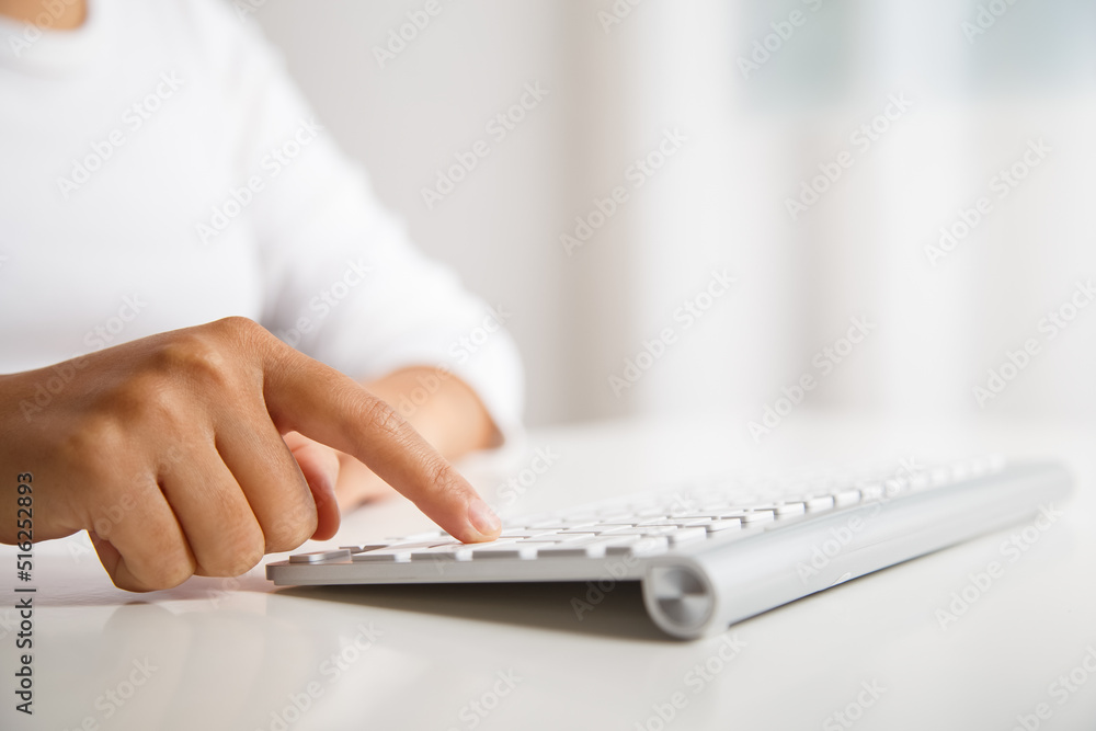 Female hand pressing enter key on wireless keyboard. Female hand pressing enter key on wireless keyboard.