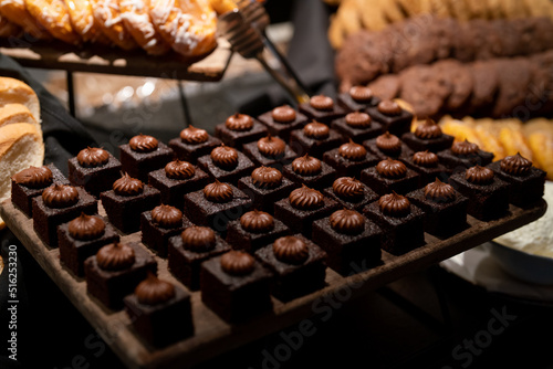 Small pastries cakes on board in buffet