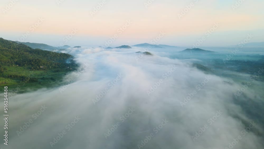 Aerial view. fly above the fog with the view of the hills and sunrise Aerial view. fly above the fog with the view of the hills and sunrise