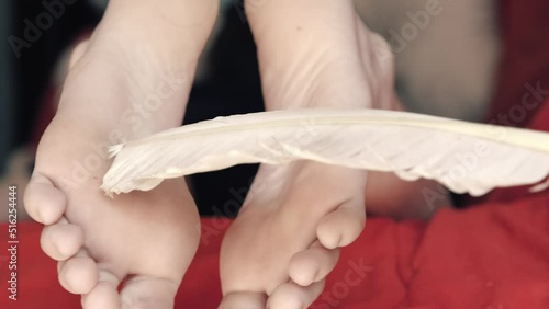 Tickling the feet of a young person laying on the sofa. Annoying prank. Closeup shot.
