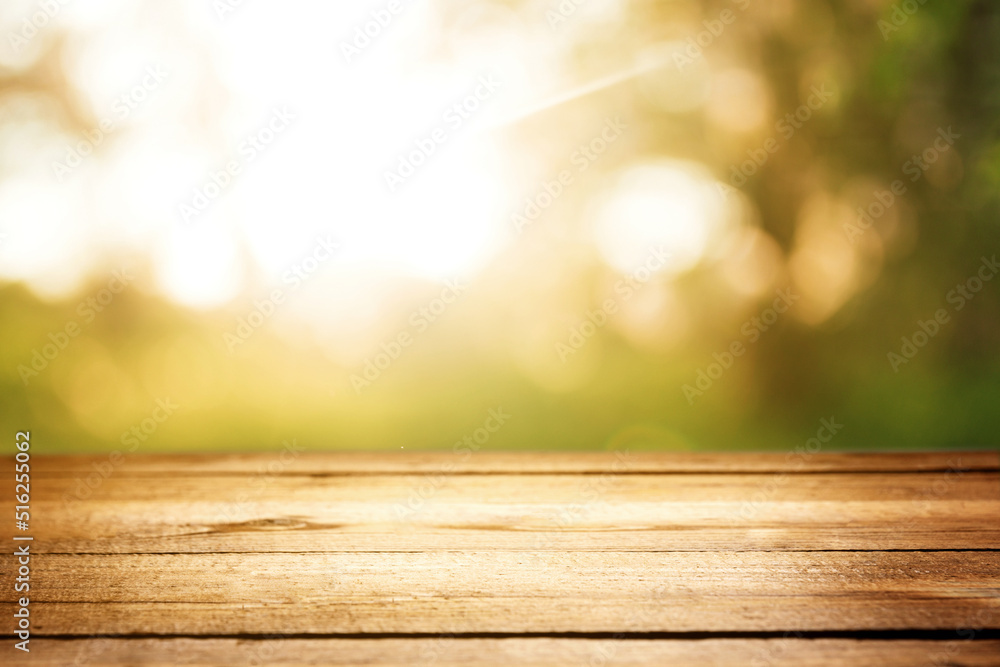 Empty rustic wooden texture of old wood table top, blur against green park with defocused sunlight, blurred foliage backyard background. Display mock up, montage your product, design key visual layout Empty rustic wooden texture of old wood table top, blur against green park with defocused sunlight, blurred foliage backyard background. Display mock up, montage your product, design key visual layout