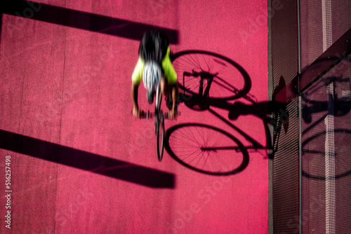 Motion blur cyclist riding fast on a pink cycle path cycleway