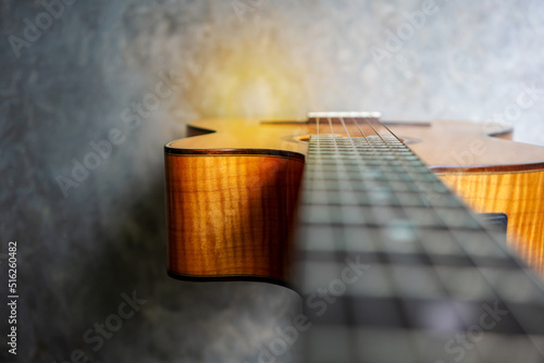 Nylon classical guitar neck and body on concrete background.