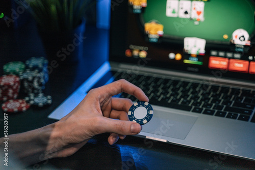 Young man play online poker in laptop.