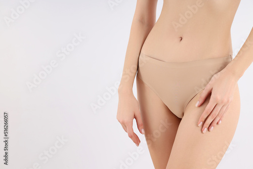 Concept of weight loss with slim young woman on light background