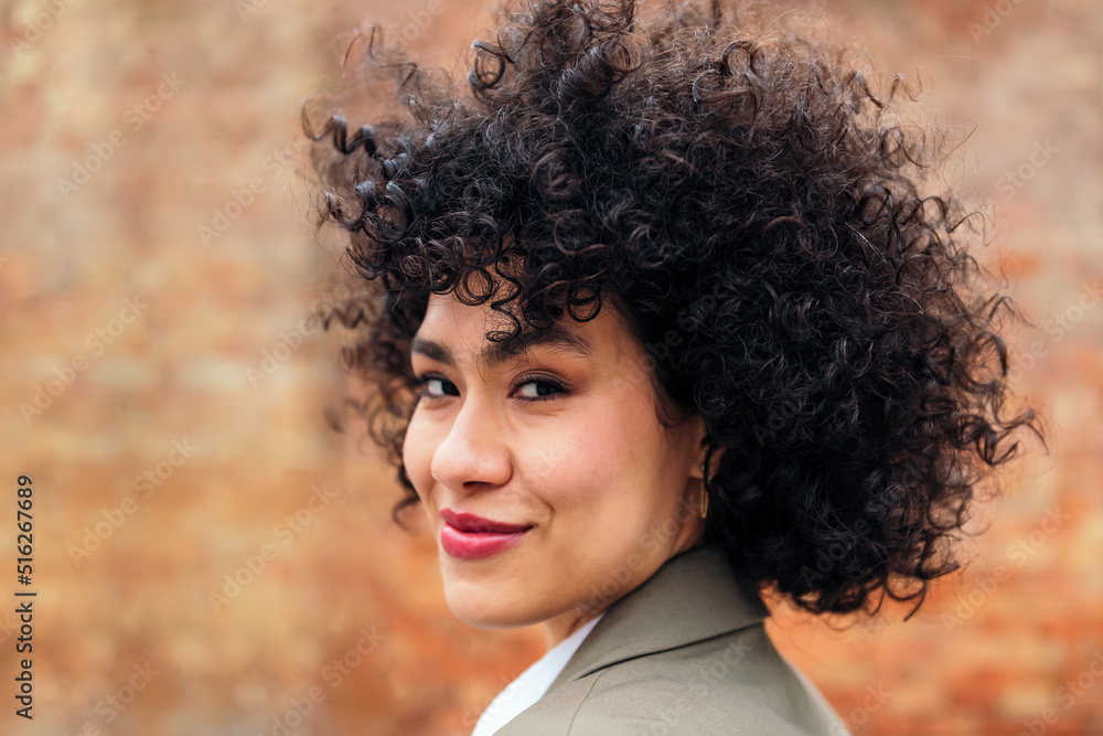 portrait of a young latin woman with curly hair smiling looking at the camera, concept of youth and happiness, copy space for text portrait of a young latin woman with curly hair smiling looking at the camera, concept of youth and happiness, copy space for text