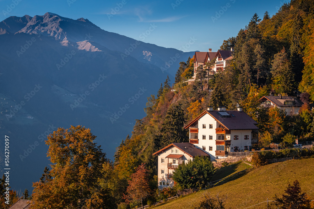 Hafling, Italy - Traditional tirol houses at Hafling - Avelengo on a warm autumn sunset with the Italian Dolomites in South Tyrol at background Hafling, Italy - Traditional tirol houses at Hafling - Avelengo on a warm autumn sunset with the Italian Dolomites in South Tyrol at background