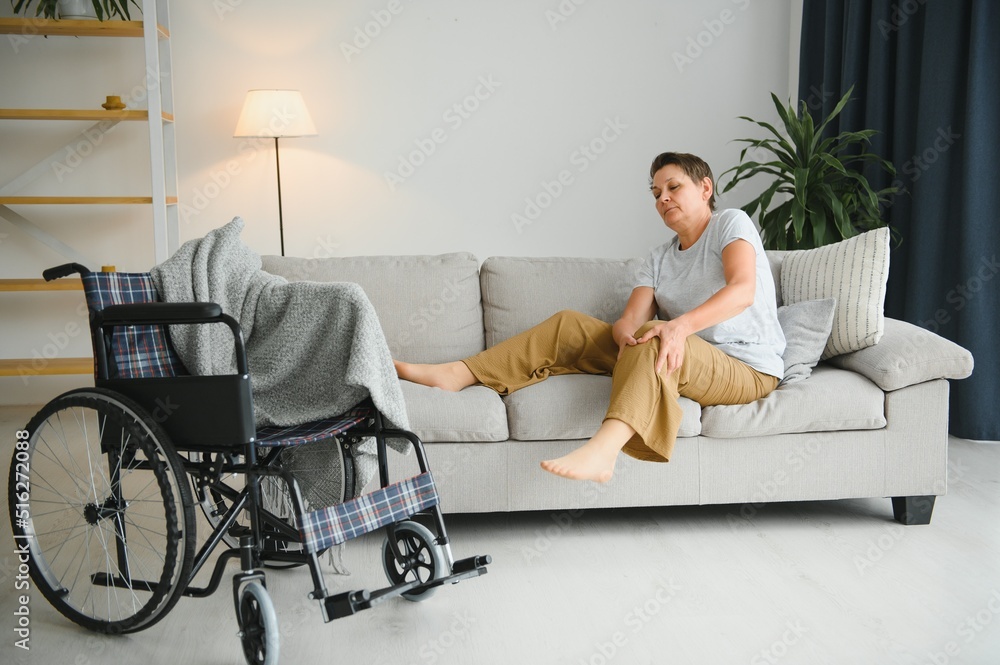 Brunette woman on couch near wheelchair