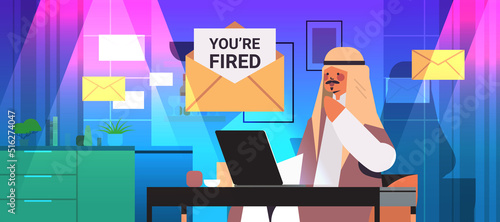 arab businessman at workplace with envelope written text you are fired dismissal unemployment jobless employee job reduction