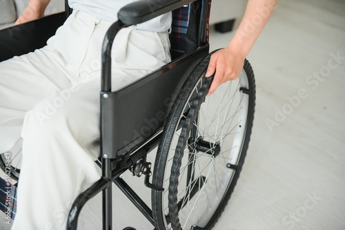 Woman in wheelchair's hand on wheel close up
