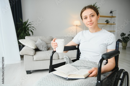 Woman in wheelchair reading book at home