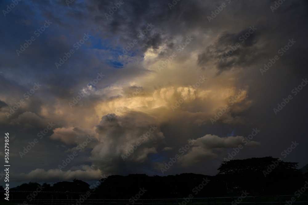 Before a heavy rainstorm, the sky was covered with clouds and strong winds, the dark clouds looked like huge black smoke from an erupting volcano. Concept of natural disaster or rainy season Before a heavy rainstorm, the sky was covered with clouds and strong winds, the dark clouds looked like huge black smoke from an erupting volcano. Concept of natural disaster or rainy season