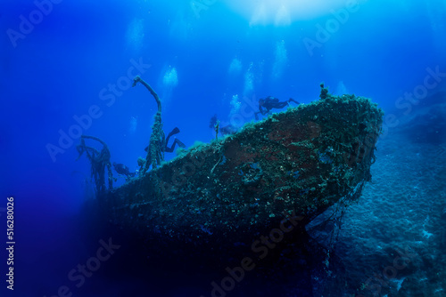 A group of unrecognizable scuba divers explores a sunken shipwreck at the bottom of the Aegean Sea in Greece, Kea island            photo