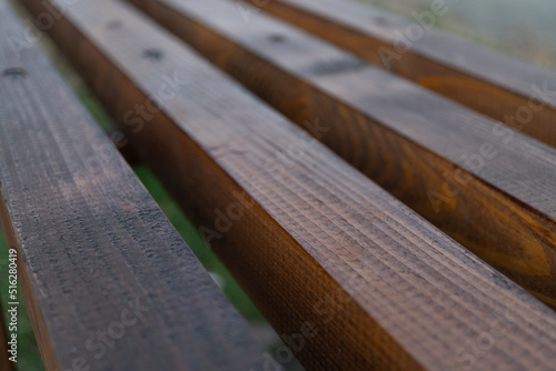 Bench made of wooden planks in the park, close up