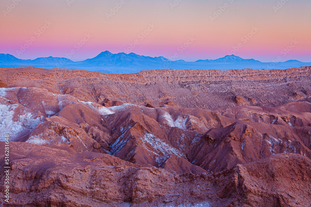 Desolate desert landscape with bare rocks in the Moon valley (Valle de la Luna) in the vicinity of San Pedro de Atacama in the blue hour after sunset