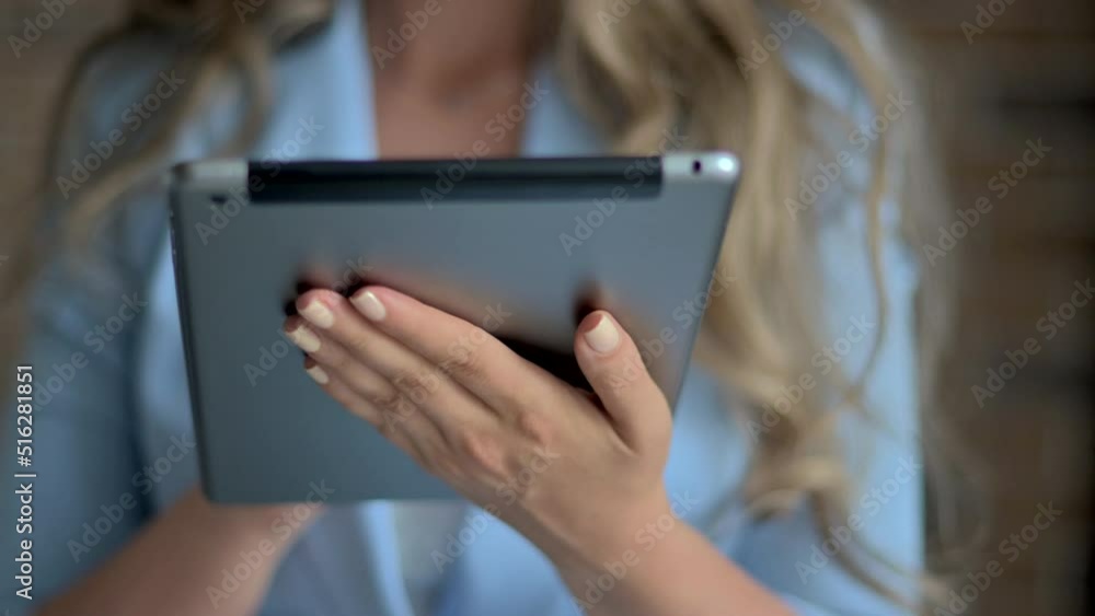 Woman wearing blue business suite working at the office using tablet Woman wearing blue business suite working at the office using tablet