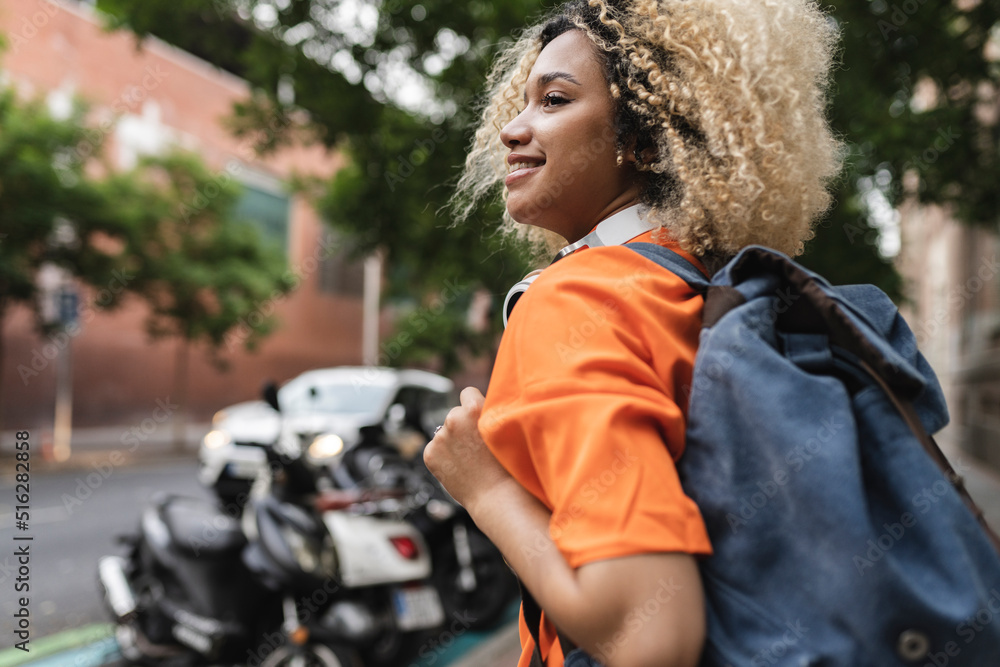 Smiling woman with backpack standing at street Smiling woman with backpack standing at street