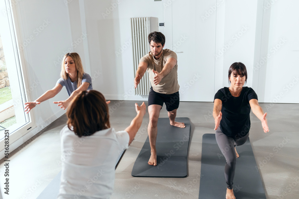 Man and women practicing yoga in exercise class Man and women practicing yoga in exercise class