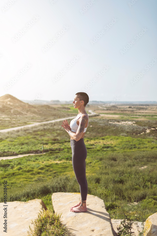 Woman with hands clasped standing on cliff at Bardenas Reales in Spain