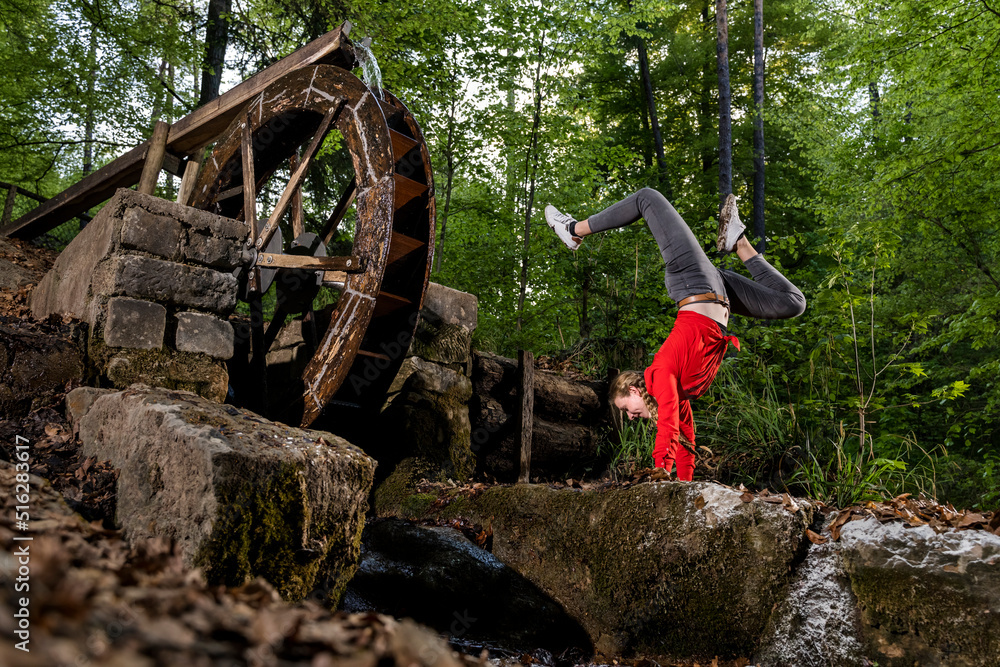 Young woman practicing handstand in forest Young woman practicing handstand in forest