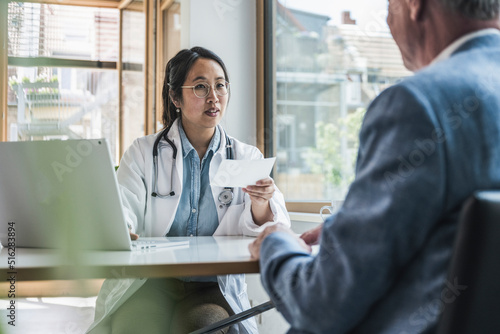 Doctor discussing with patient over prescription in medical clinic photo