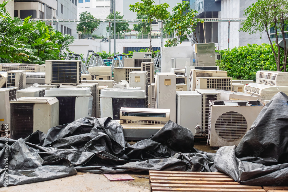 A lot of Air conditioners stacked up in a pile to disposal at recycling garbage dump. Stack of