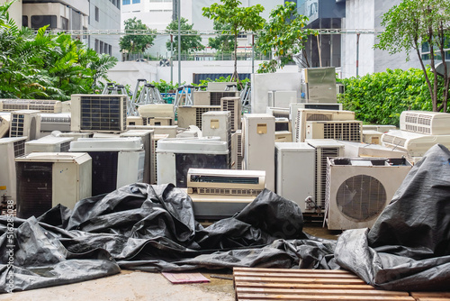 A lot of Air conditioners stacked up in a pile to disposal at recycling garbage dump. Stack of old and dirty air conditioners defective and discarded for recycling process industry. Old appliances. photo